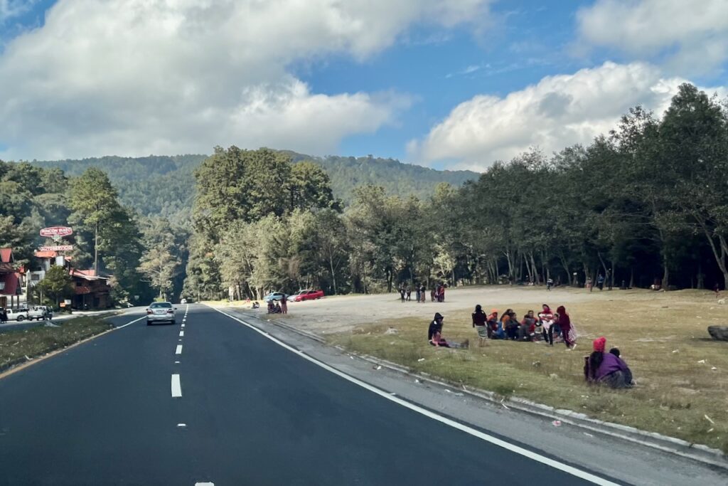 People waiting for buses along the road from Antigua toward lake Atitlan, Guatemala